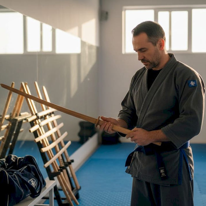 Martial artist inspects sword in training studio