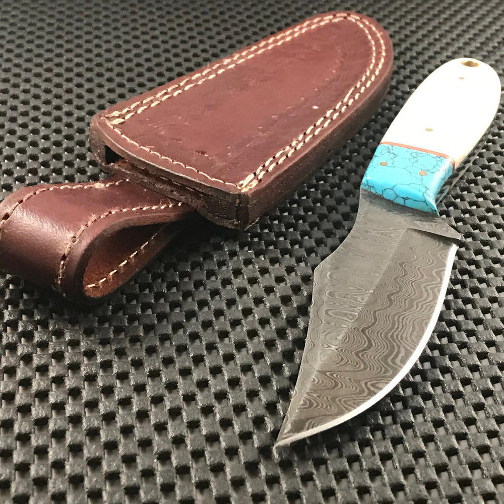 Handmade blue Damascus steel skinning knife with horn handle and leather sheath